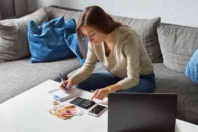 Frau mit Taschenrechner und Bargeld - © Lukasz - stock.adobe.com