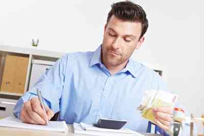 Mann mit Stift und Geldscheinen in den Händen - © Robert Kneschke - stock.adobe.com